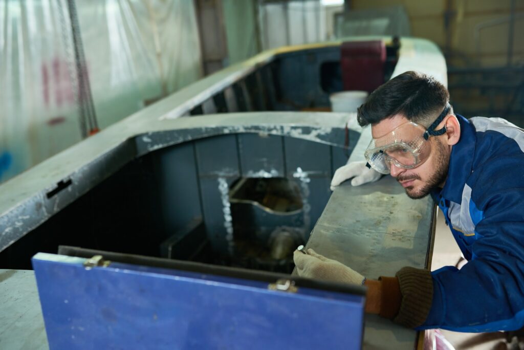 Handsome Man Repairing Boat in Workshop